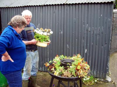 Dan (owner) showing Carole the old pig feeder turned planter