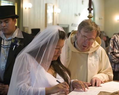 Bride signing register in St. Thomas Church, Moose Fatory