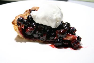Slice of fresh blueberry pie with mascarpone whipped cream