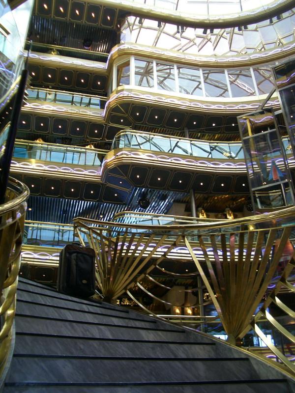 Suitcase descends the stairs in the ships lobby