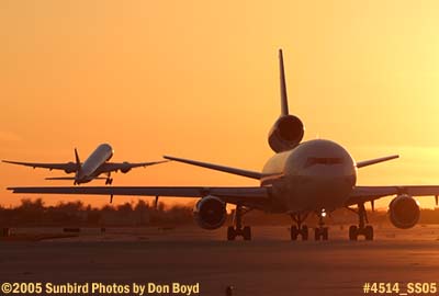 Cargo DC-10 taxiing as American Airlines B777-223 lifts off at sunset airliner aviation airline stock photo #4514