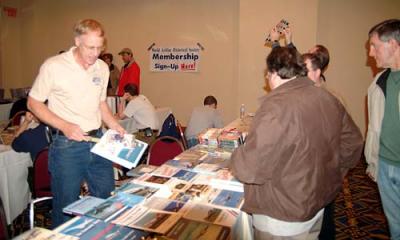 Keith Armes (left) of World Transport Press assisting customers at the 2005 Boston Airline Show, photo #7225