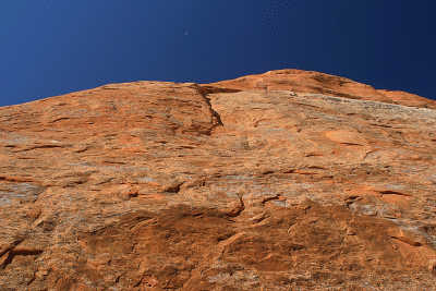 A sliver of moon against red rock