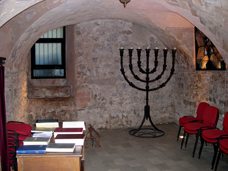 Inside the Major Synagogue: Wall from the 13th-17th centuries. Menorah of forged iron by Majorcan artist  Ferrn Aguil.