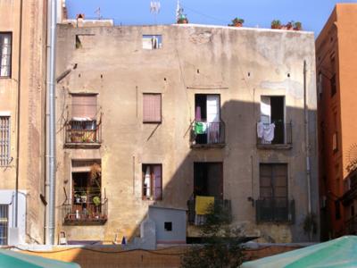 The back of apartments behind Mercat de la Boquera off of Las Ramblas - flower pots on roof and balconies.