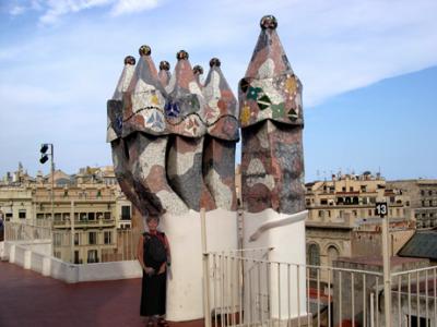Gaud's Casa Batli: Judy next to the chimneys on the roof. Barcelona is in the background.