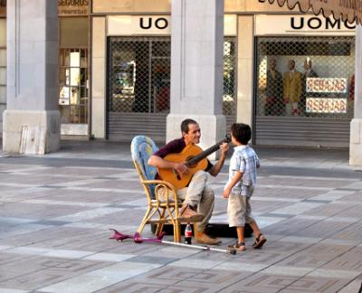 Flamenco guitarist (street performer) and a boy. The guitarist played while we ate dinner on Plaça Major in Palma.