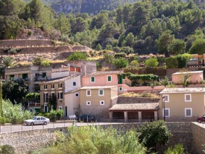 Estellencs on the north coast of Mallorca: An old, covered, public wash house is in the foreground.