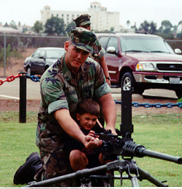 Me showing my son Ian a M-2 .50cal machine gun. (no... it's not loaded) photo taken by my dad at a family day at my marine unit