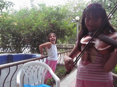 Little cousin is amused by the voice of the violin.
