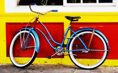 blue bike on yellow & red wall
