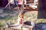 018 - Girl working at laundry, retrieving bucket from the well