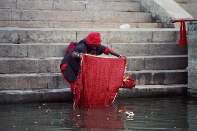 Sadhu washes a deity's shawl