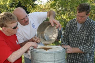 Mom, Dad and Ryan straining the cider
