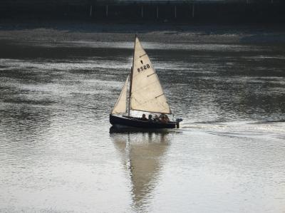 Small sail boat cruising down river past Fulham.