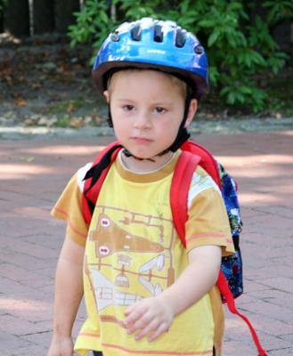 Max getting out of kindergarden with his backpack and helmet on looking for bike to head for home for lunch..