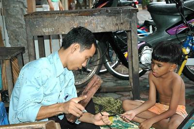 Phnom Penh, Father and son, making souvenirs