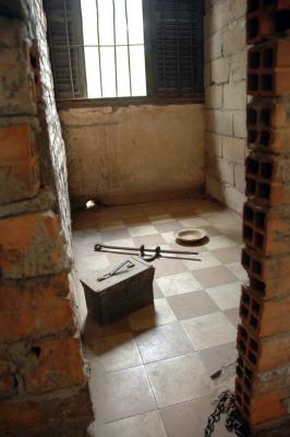 A jail cell and a toilet  and foot Iron