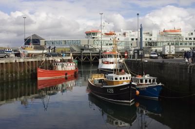 The ferry ship Hamnavoe looms over smaller classic workboats... two lobster boats, a small ferry, and a dive boat.