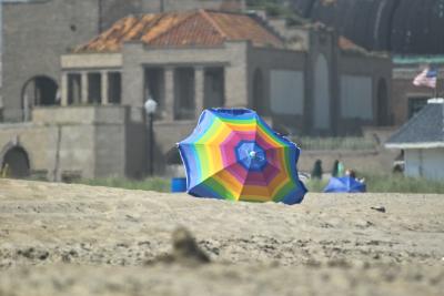 Beach umbrella with abandoned Asbury Park early 1900s Casino in the background