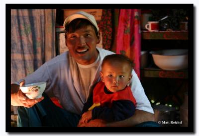 A bowl of tea in one hand and his son in the other, Bayan-Olgii Aimag