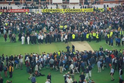 Close-up of cricket fans examining the wicket at Lords