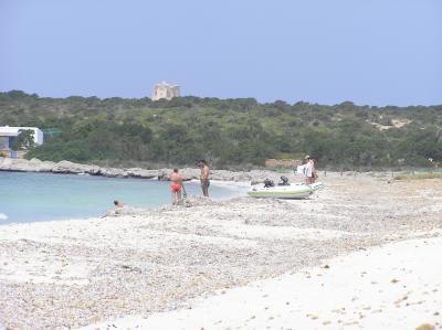 Espalmador beach with old defence tower in the distance