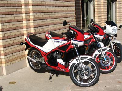 Three clean RZ350 Yamahas in parking lot.