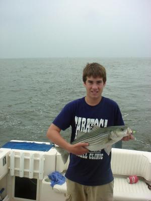 7/7/05 - Kyle Nichols Family Charter - son shows off a nice Striper for release