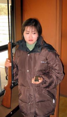 A girl working at the shooting range.  No joy in her eyes