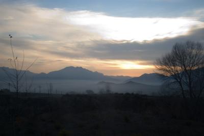 Low mist in the valley as the sun rises over the mountains.