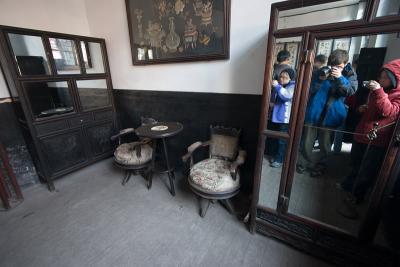 Some furniture inside one of the many rooms.  Photographers reflected in the mirror.