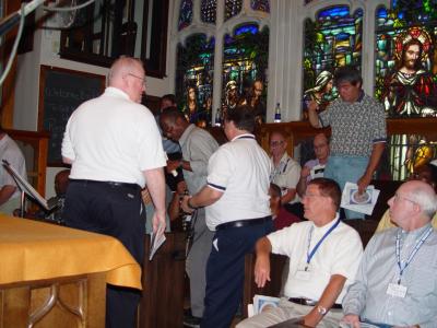 CHOIR MEMBERS FIND THEIR PLACES BEFORE THE MASS BEGINS
