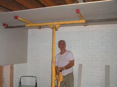 Papa uses a specially rented hoist to put the drywall panels on the ceiling in the new playroom/bedroom.PICT0053.JPG