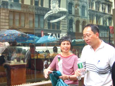 An Asian couple, Zales store and the reflections of the street shopping outside