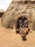 Mursi woman in front of hut
