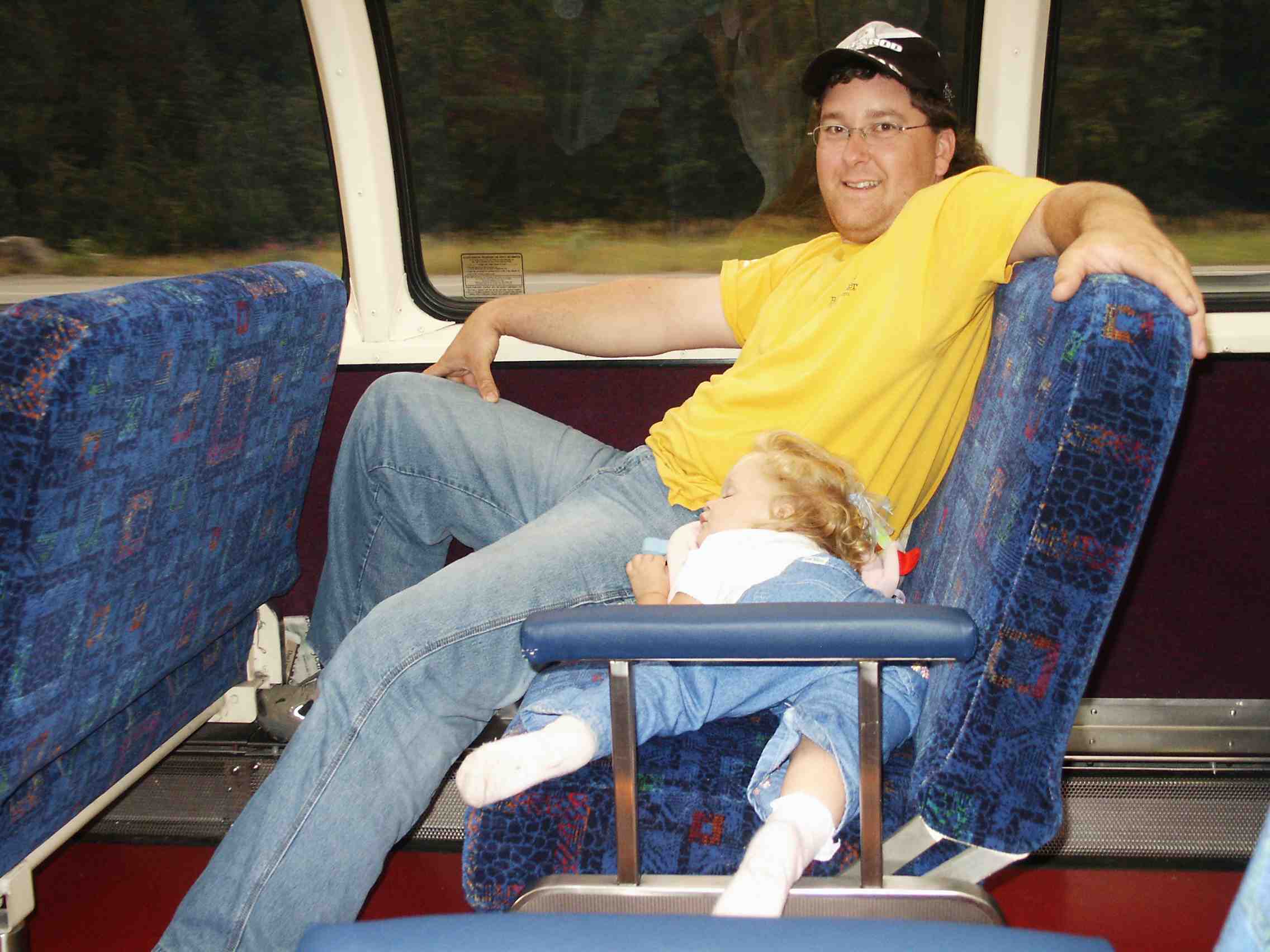 Lilli asleep on the train with daddy.jpg