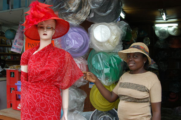 Dora Lamptey of God Is God Collectibles showing off hats she makes herself