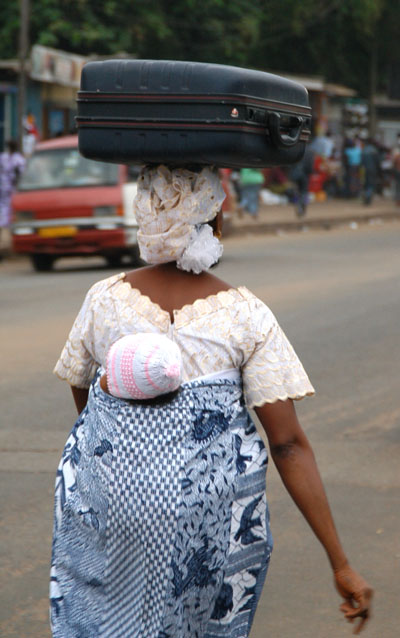Woman carrying a baby and a suitcase with 2 hands free