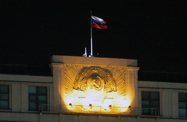 Russian flag over an old Soviet hammer and sickle on the Hotel Moskva
