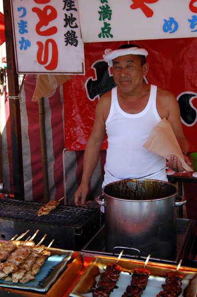 Man selling grilled chicken-on-a-stick