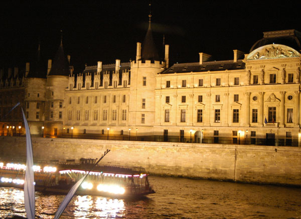 Tour boat passing the Conciegerie at night