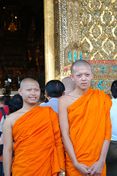 Monks posing with the Temple of the Emerald Buddha