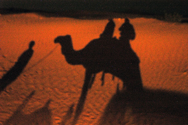 Shadow of camel riders at night