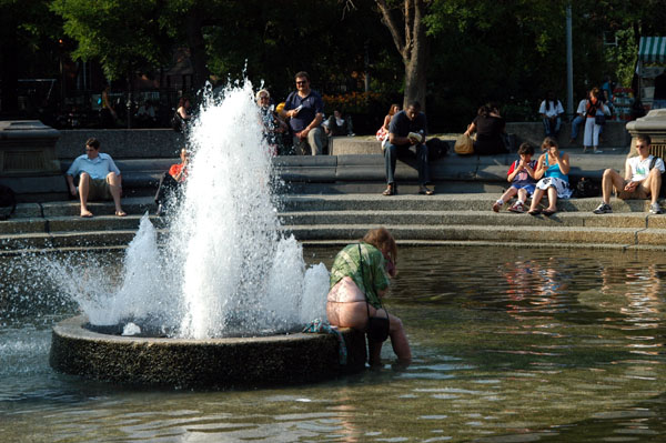 Homeless woman bathing midday in the Washington Square fountain