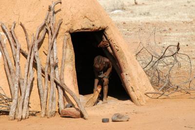 Himba child sweeping out the hut
