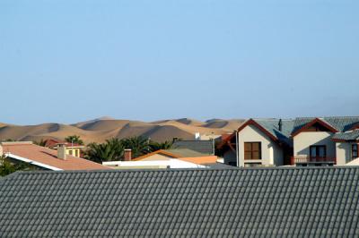 Driving into town, the dunes rise over the rooftops