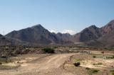 A dirt road heading for the mountains off the main highway E99