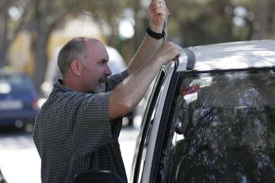 John breaking into his car after locking keys in